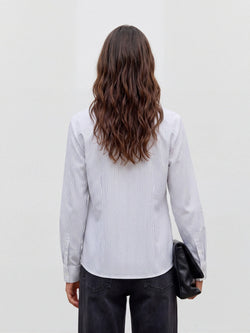 Camisa branca às riscas finas pretas na modelo, vista de trás